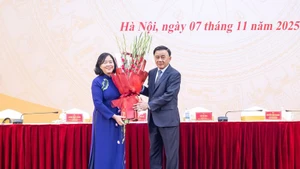 El miembro del Buró Político y permanente del Secretariado del Comité Central del Partido Comunista de Vietnam (PCV), Tran Cam Tu, entrega flores para felicitar a Bui Thi Minh Hoai, nueva presidenta del Frente de la Patria. (Foto: VNA)
