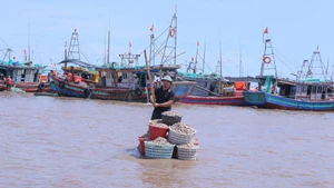 Pescadores transportan mariscos desde sus barcos hasta la orilla utilizando balsas, para luego venderlos en el mercado. (Foto: VNA)