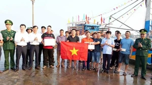 El vicepresidente del Comité Popular Provincial de Quang Tri, Le Van Bao (fila superior, cuarto desde la derecha), entrega regalos y recuerda a los pescadores el estricto cumplimiento de las normas contra la pesca INDNR. (Foto: VNA)
