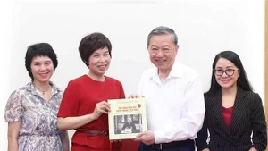 La directora general de la Agencia Vietnamita de Noticias (VNA), Vu Viet Trang, entrega al secretario general del Partido Comunista del país (PCV), To Lam, el libro de fotos bilingüe vietnamita-inglés “100 años de la Prensa Revolucionaria de Vietnam. (Foto: VNA)