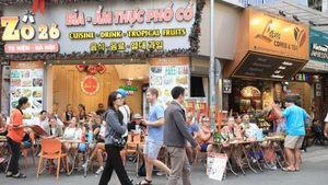 Turistas extranjeros disfrutan de la gastronomía en la calle Ta Hien, Hanói. (Foto: VNA)