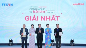 La directora general de la VNA y presidenta del Consejo del Premio, Vu Viet Trang, y el viceministro de Cultura, Deportes y Turismo, Ta Quang Dong, entregan el primer premio a los autores. (Foto: VNA)