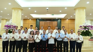 El miembro permanente del Secretariado, Tran Cam Tu, junto con miembros del Buró Político y del Secretariado y los delegados en la reunión con la Junta Permanente del Comité del Partido de Vinh Long.