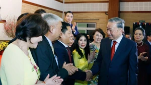 El secretario general del Partido Comunista de Vietnam, To Lam, y funcionarios y personal de la Embajada y representantes de la comunidad de connacionales en Camboya. (Foto: VNA)
