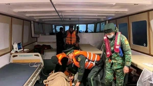 Las guardias fronterizas de Quang Ninh ayudan a Kosuge Kimiko (nacida en 1949, de nacionalidad japonesa), quien sufre un derrame cerebral, a llegar sana y salva a tierra para recibir tratamiento de emergencia. (Foto: VNA)