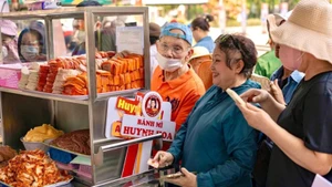 La gente compra banh mi en la tienda de Huynh Hoa. 