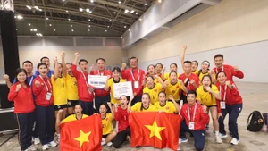 Las jugadoras y el cuerpo técnico de la selección femenina vietnamita de balonmano celebran su medalla de oro. (Foto: VNA)