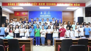 Estudiantes participantes en el curso posan para una foto con los delegados.