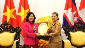 La vicepresidenta del Partido Popular de Camboya, Men Sam An, entrega un obsequio conmemorativo a la presidenta del Comité Central del Frente de la Patria de Vietnam, Bui Thi Minh Hoai. (Foto: VNA)