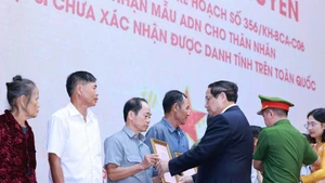 El primer ministro Pham Minh Chinh entrega la notificación de los resultados del examen de ADN a los familiares de los mártires. (Foto: VNA)