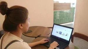 Una muchacha realiza sus compras en línea (Foto: VNA)