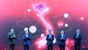 El miembro del Buró Político y permanente del Secretariado del Comité Central del PCV, Tran Cam Tu, junto con los delegados, realiza el acto de lanzamiento de la App TGDV en dispositivos móviles.