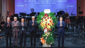El presidente de la Unión de Organizaciones de Amistad de Vietnam, Phan Anh Son, entrega flores para felicitar a la Asociación Vietnam-Estados Unidos. 
