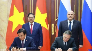 El primer ministro vietnamita, Pham Minh Chinh (de pie, a la izquierda), y su homólogo ruso, Mikhail Mishustin (de pie, a la derecha), presencian la firma del acuerdo entre ambos gobiernos para la cooperación en la construcción de una central nuclear en el país indochino. (Foto: VNA)