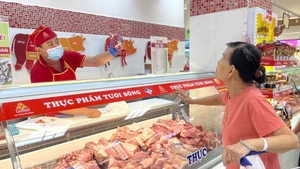 Una cliente compra carne de cerdo en el supermercado Coopmart en Ciudad Ho Chi Minh. (Foto: VNA)