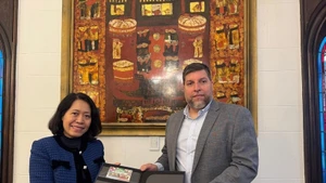 El diputado Víctor Aldaya entrega a la embajadora de Vietnam en Aregentina, Ngo Minh Nguyet, un juego de sellos emitidos por Correos del Uruguay en diciembre de 2013, en conmemoración del 20º aniversario de las relaciones diplomáticas entre Vietnam y Uruguay, con el retrato del General Vo Nguyen Giap. (Foto: VNA)