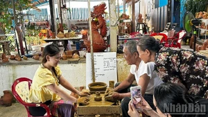 Turistas experimentan la elaboración de cerámica en la aldea de alfarería de Thanh Ha. 