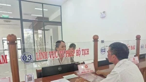 Las personas hacen trámites administrativos en el día del inicio de la prueba del gobierno de dos niveles en el distrito de Pleiku, Gia Lai. (Foto: VNA)