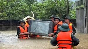 Oficiales y soldados de la Brigada 409 y del Alto Mando Militar de la provincia de Bac Ninh ayudan a los habitantes de la comuna de Xuan Luong a trasladar personas y bienes. (Foto: VNA)