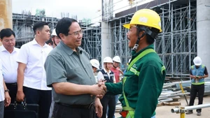 El primer ministro Pham Minh Chinh con los trabajadores que construyen el proyecto del Aeropuerto Internacional de Phu Quoc. (Foto: VNA)