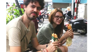 Visitantes internacionales se deleitan con la comida callejera de Hanói. (Foto: VNA)