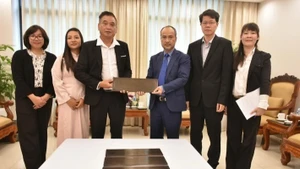 Nguyen Trung Kien, presidente del Comité Estatal para los Vietnamitas en el Extranjero, entrega la placa de bronce a Do Van Du, representante de la comunidad vietnamita en Vanuatu.