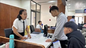 Funcionarios del Centro de Administración Pública del Distrito de Tam Ky, en la ciudad de Da Nang, guían a los ciudadanos en los trámites. (Foto: VNA)