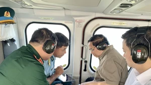 El primer ministro Pham Minh Chinh (segundo desde la derecha) realiza una inspección aérea desde un helicóptero de la autopista Ca Mau-Dat Mui, la carretera que conduce a Hon Khoai y el puerto de doble uso de Hon Khoai. (Foto: VNA)