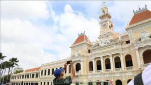 Visitantes internacionales exploran el centro de Ciudad Ho Chi Minh en un autobús de dos pisos. (Foto: VNA)
