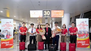 Un directivo de Vietjet da la bienvenida al vuelo inaugural Hanoi-Chengdu junto a la tripulación y los pasajeros en el Aeropuerto Internacional de Noi Bai. (Foto: Vietjet)