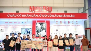 Un gran número de jóvenes se muestran entusiasmados al recibir la publicación especial del periódico Nhan Dan. (Foto: The Dai)