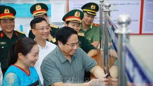 El primer ministro de Vietnam, Pham Minh Chinh, inspecciona el trabajo en el centro de servicios administrativos públicos de la comuna de Bat Mot, provincia de Thanh Hoa. (Foto: VNA)