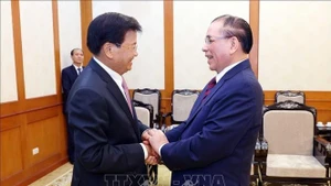 El secretario general del PPRL y presidente de ese país, Thongloun Sisoulith, sostiene un encuentro con el exsecretario general del PCV, Nong Duc Manh (Foto: VNA)
