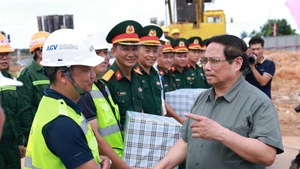 El primer ministro Pham Minh Chinh (derecha) se reúne con las unidades encargadas de la construcción de la terminal T2 del Aeropuerto Dong Hoi (Foto: VNA)
