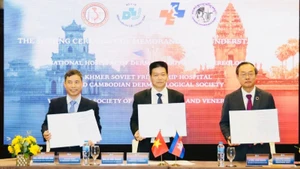 Representantes de las entidades en la ceremonia de firma. (Foto: Nhan Dan)