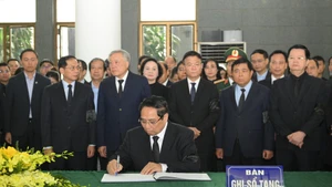 El primer ministro Pham Minh Chinh escribe en el libro de condolencias (Foto: Nhan Dan)