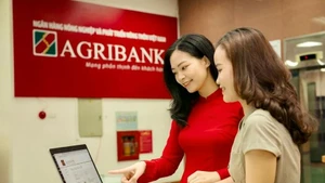 Empleados del Banco de Desarrollo Agrícola y Rural de Vietnam (Agribank) orientan a sus clientes sobre cómo realizar transacciones seguras en canales digitales. (Foto: qdnd.vn)