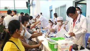 El personal médico realizan chequeos a las personas que participan en el programa. (Foto: VNA)