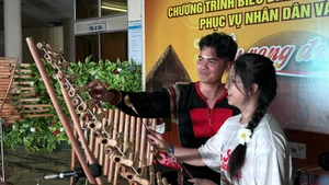 Una joven connacional experimenta el xilófono T'rung (Foto: VNA)