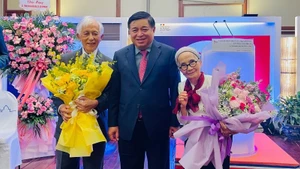 El viceprimer ministro vietnamita Nguyen Chi Dung felicita a los profesores Jean Tran Thanh Van y Le Kim Ngoc en la ceremonia. (Foto: Nhan Dan)