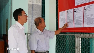 Electores consultan las reseñas biográficas de los candidatos al Consejo Popular de la comuna de Tan Hong (Dong Thap) para el período 2026-2031. (Foto: VNA)