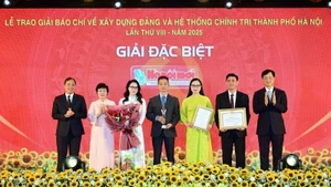 Nguyen Duy Ngoc, secretario del Comité del PCV en Hanói, y Hoang Trung Dung, subjefe permanente de la Comisión de Organización del Comité Central del Partido, entregan el Premio Especial a autores del periódico Hanoimoi.