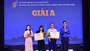 Bui Quang Huy, miembro suplente del Comité Central del Partido Comunista de Vietnam y primer secretario del Comité Central de la Unión de Jóvenes Comunistas Ho Chi Minh, y Nguyen Pham Duy Trang, secretario del Comité Central de la Unión de Jóvenes Comunistas Ho Chi Minh, entregan el Premio al colectivo de autores del periódico Nhan Dan. (Foto: hanoimoi.com.vn)