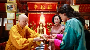 El muy venerable Thich Thanh Nha entrega a la reina butanesa Jetsun Pema Wangchuck y Nguyen Thi Minh Nguyet, esposa del presidente vietnamita, hojas de Bodhi elaboradas artesanalmente. (Foto: Nhan Dan)