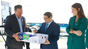 El primer ministro Pham Minh Chinh firma un paquete de carne de res exportada a Vietnam. (Foto: VNA)
