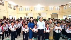 El embajador de Vietnam en Laos, Nguyen Minh Tam y su esposa se toman una foto con representantes escolares y alumnos de la Escuela Bilingüe Laos-Vietnamita Nguyen Du. (Foto: VNA)