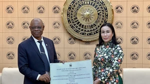 Martin Kabaluapa Kapinga (izq.), jefe de la División de Oficinas Nacionales del WWF, entrega una donación simbólica a Nguyen Thi Anh Thi, vicepresidenta del Comité Popular de Da Nang, para apoyar los esfuerzos de recuperación de la ciudad central tras las fuertes lluvias y el paso del tifón Kalmaegi (Foto: VNA)