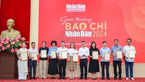 Le Quoc Minh, presidente-editor del periódico Nhan Dan, entrega el premio A a los autores y representantes de los grupos de autores. (Foto: THE DAI)