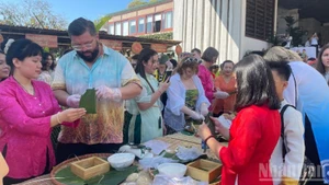 Turistas participan en el concurso de elaboración de “banh chung”.