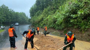 Guardias fronterizos de la ciudad de Hue excavan tierra y rocas para nivelar la carretera afectada por el deslizamiento de tierra en el paso de Pe Ke, en la comuna de A Luoi 1. (Foto: VNA)